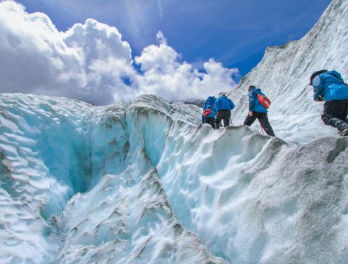 four people climbing mountain at daytime