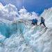 four people climbing mountain at daytime